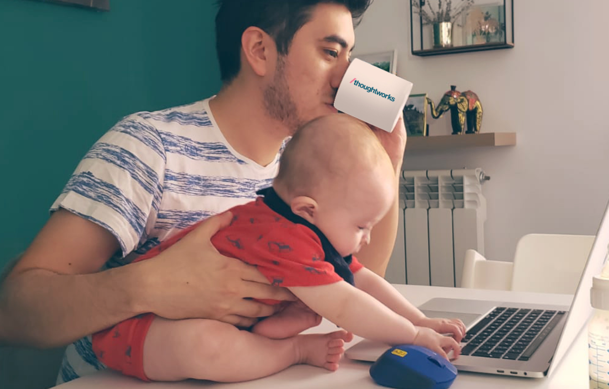 Thoughtworker com seu filho segurando uma xícara e olhando para o computador. Thoughtworker com seu filho segurando uma xícara e olhando para o computador.